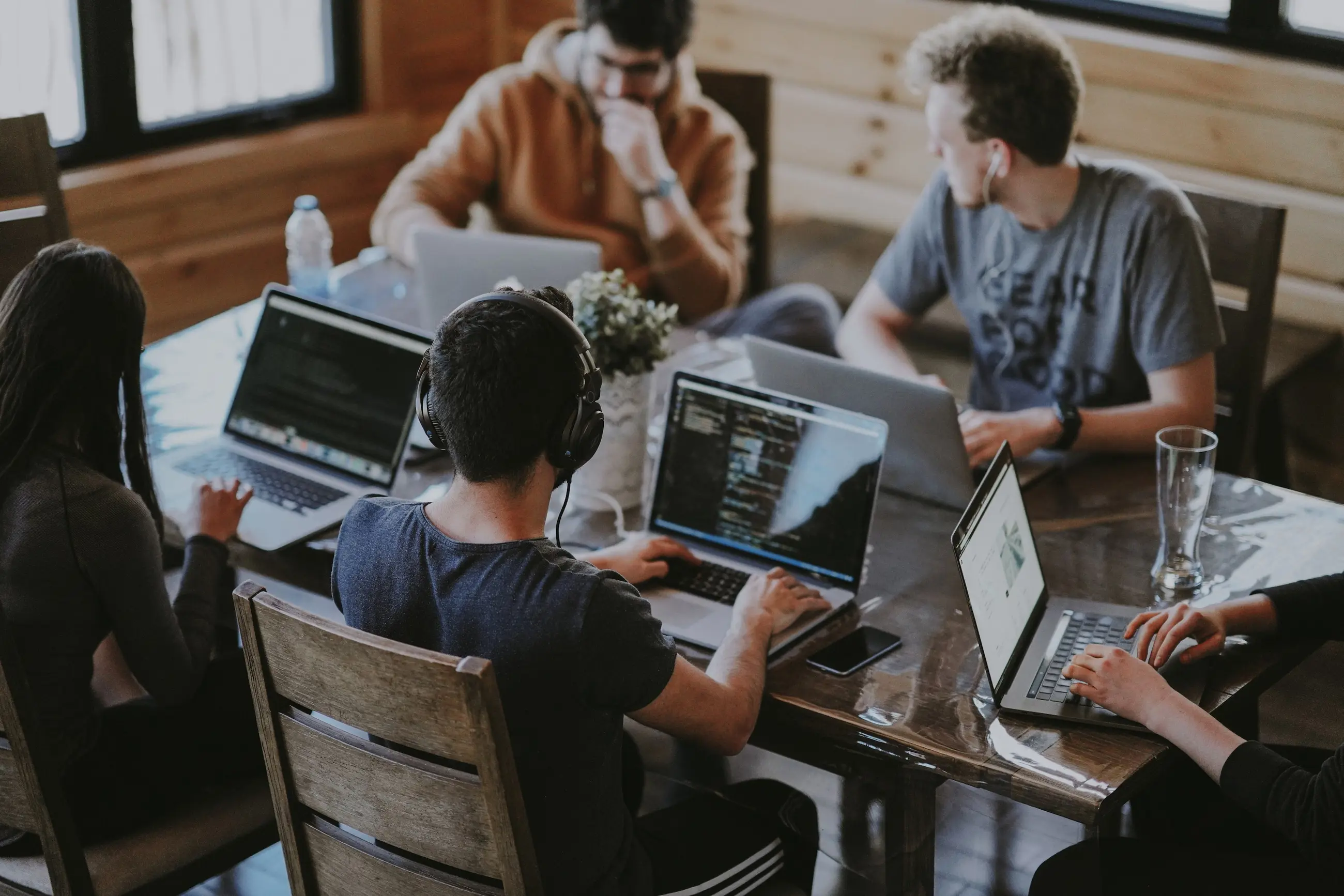 Group of students sitting around laptops at a table